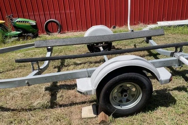 Slide: The Image of Boat trailer for 2009 Pro-Line Pro Lite 20 CC, parked on grass near red building. - 14