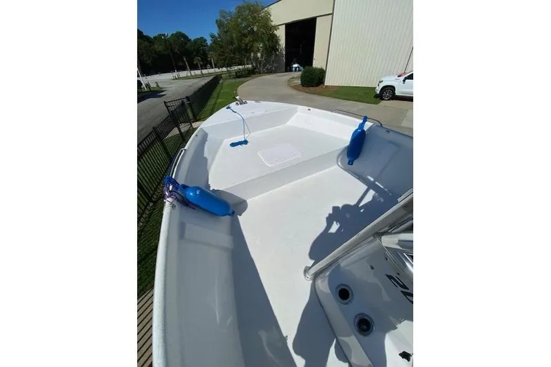 Slide: The Image of 2009 PRO LITE 20 CC boat deck with blue fenders, parked near a building. - 7