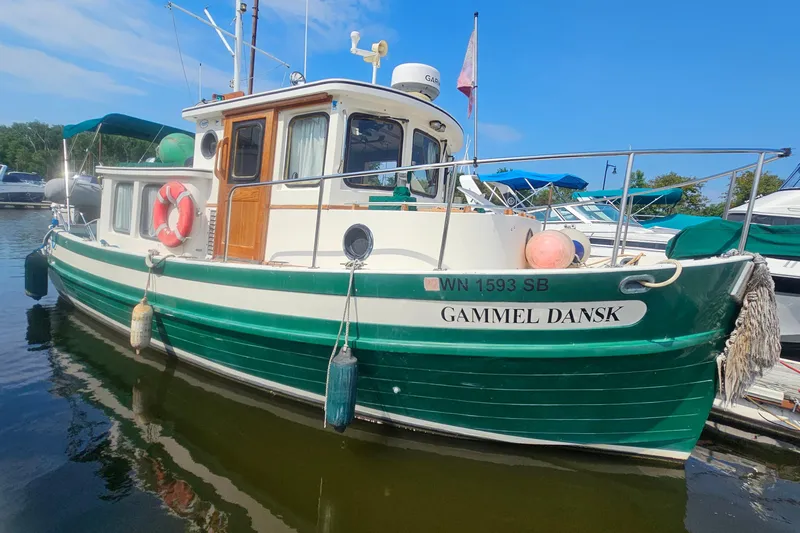 The Image of 1982 Nordic Tug 26 boat named "Gammel Dansk" docked in a marina. - 1
