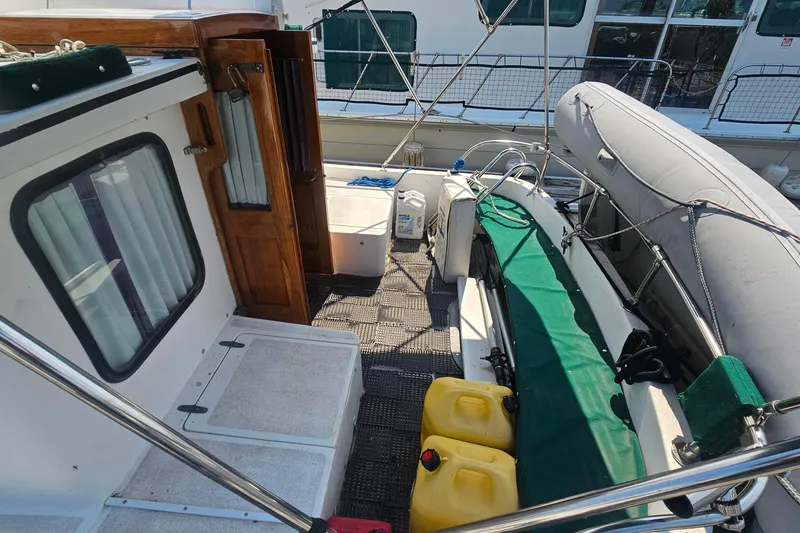 Slide: The Image of 1982 Nordic Tug 26 boat deck with inflatable dinghy and storage containers. - 10