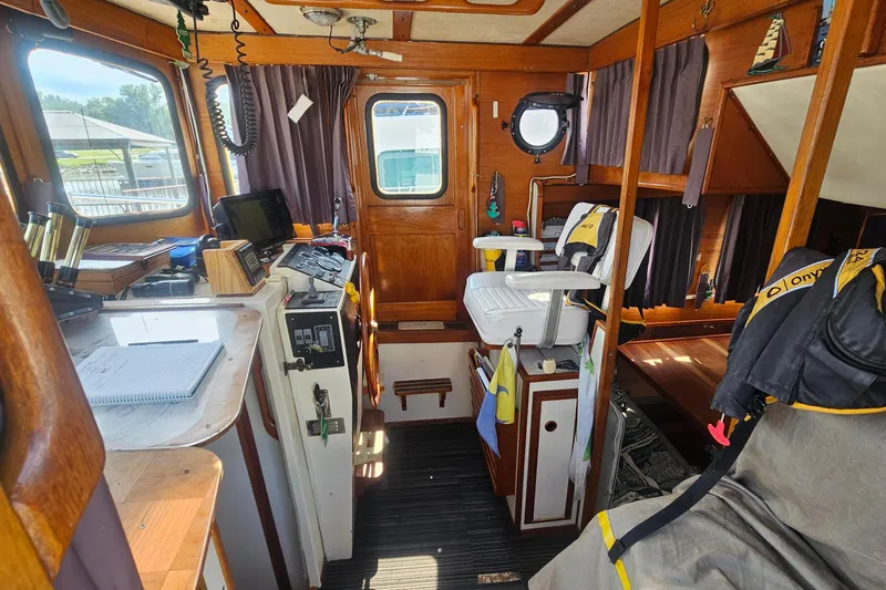 Slide: The Image of Interior of a 1982 Nordic Tug 26 boat, featuring wooden accents and navigational equipment. - 12