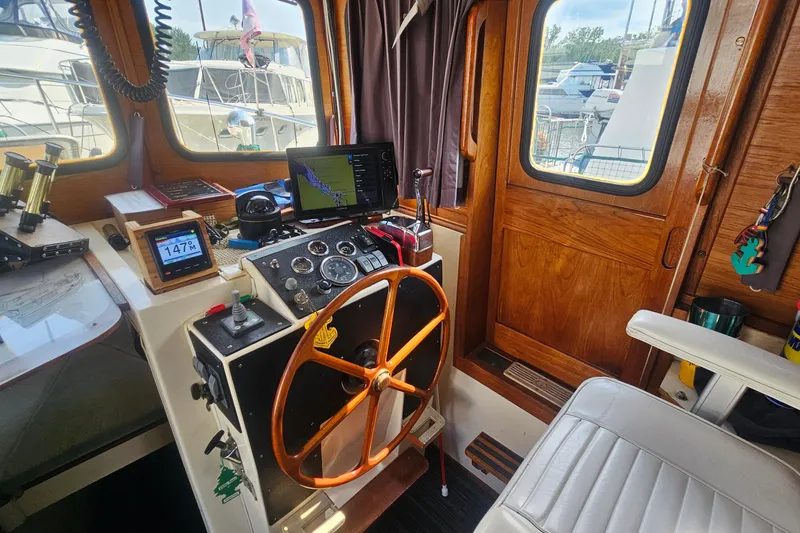 Slide: The Image of Interior of 1982 Nordic Tug 26 boat with wooden helm and navigation equipment. - 13