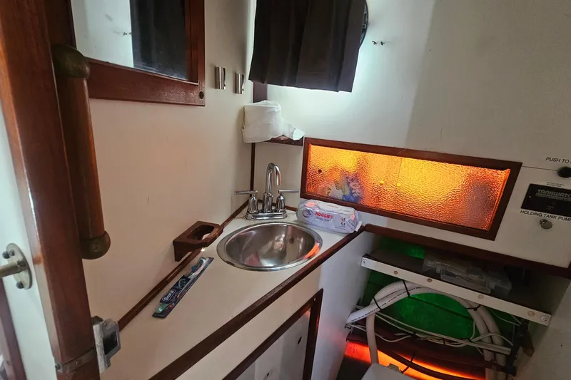 Slide: The Image of 1982 Nordic Tug 26 interior with sink, storage, and illuminated panel. - 17