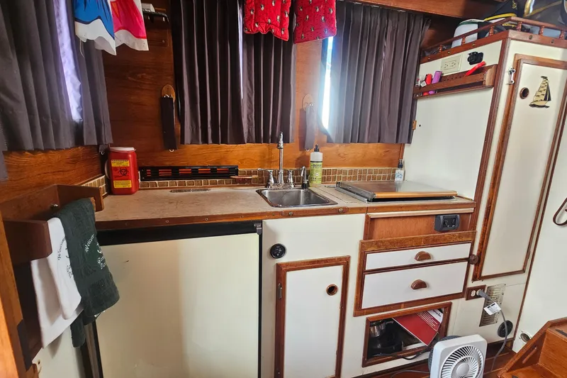 Slide: The Image of 1982 Nordic Tug 26 interior kitchen with sink, stove, and storage cabinets. - 21