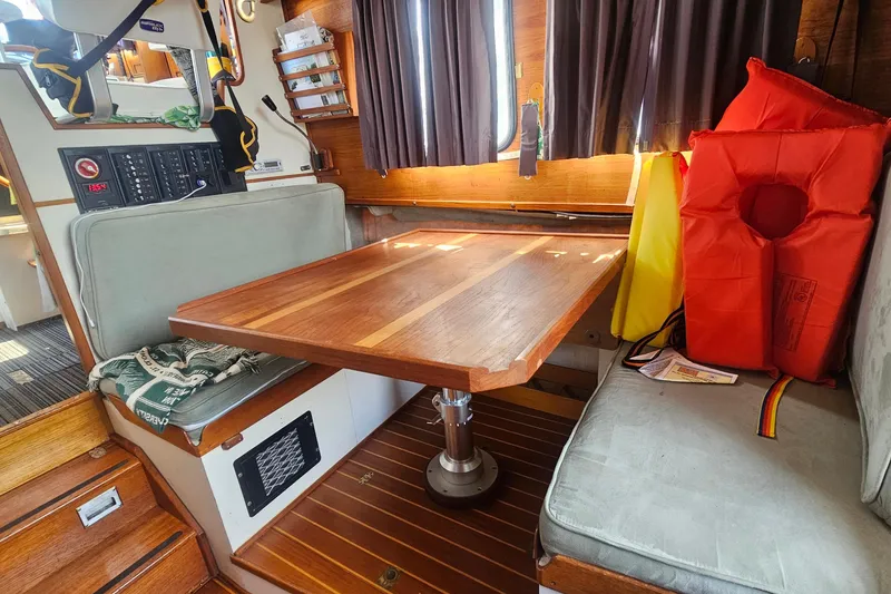 Slide: The Image of Cozy interior of a 1982 Nordic Tug 26 with wooden table and life jackets. - 22