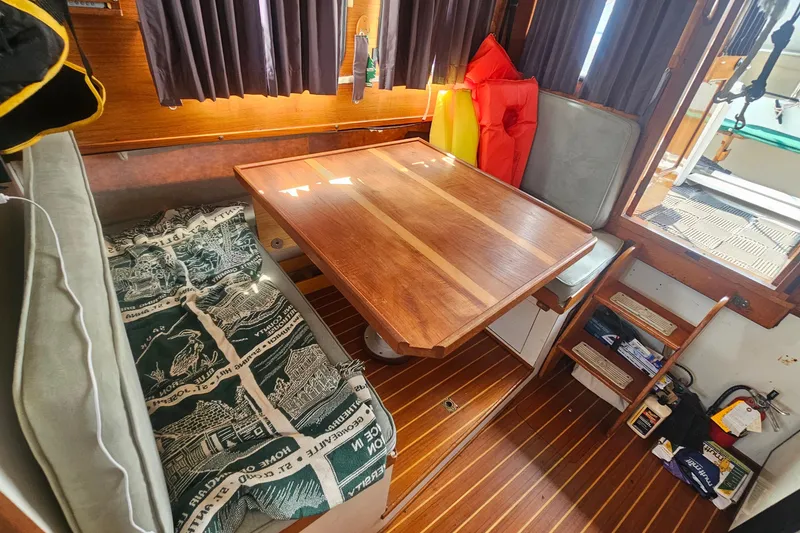 Slide: The Image of Cozy interior of 1982 Nordic Tug 26 with wooden table and seating area. - 23