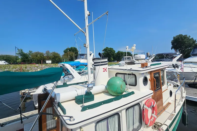 Slide: The Image of 1982 Nordic Tug 26 docked at marina, featuring classic design and nautical equipment. - 6