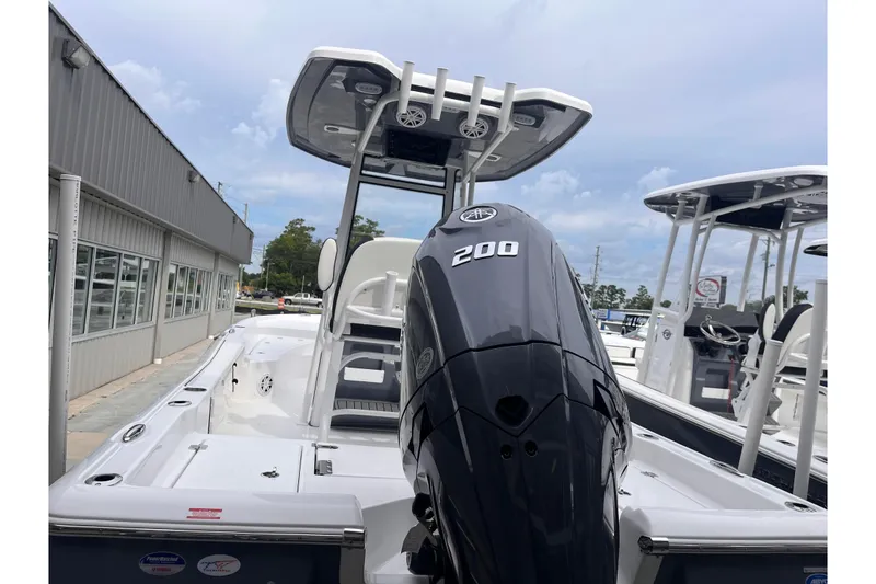 Slide: The Image of 2026 Tidewater 2210 Carolina Bay boat with powerful 200 HP engine, docked outdoors. - 2