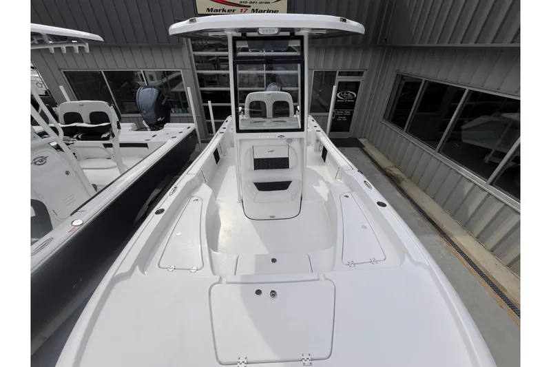 Slide: The Image of 2026 Tidewater 2210 Carolina Bay boat displayed at a marine dealership. - 7
