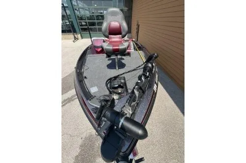 Slide: The Image of 2020 Ranger Z175 fishing boat with red seating and trolling motor, parked outdoors. - 7