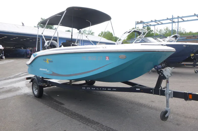 Slide: The Image of 2022 Bayliner Element M17 boat on trailer, blue hull, parked outdoors. - 3