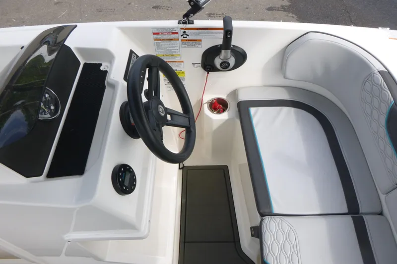 Slide: The Image of 2022 Bayliner Element M17 boat interior with steering wheel and seating area. - 7