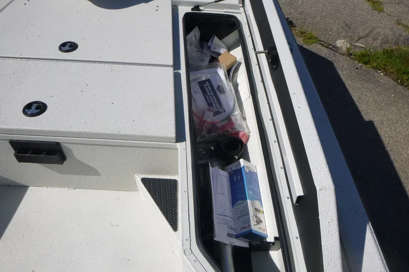 Slide: The Image of Storage compartment of 2025 Ranger RB210 boat with various items inside. - 10