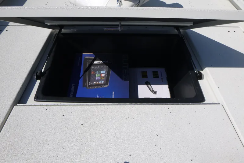 Slide: The Image of Open storage compartment on 2025 Ranger RB210 boat with electronic equipment inside. - 12