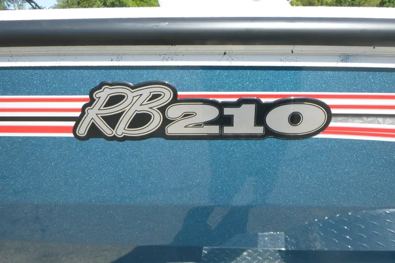 Slide: The Image of 2025 Ranger RB210 logo on blue metallic surface with red and white stripes. - 18