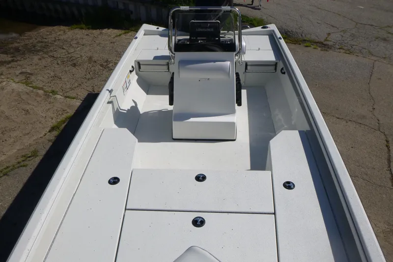 Slide: The Image of 2025 Ranger RB210 boat interior with center console and seating, docked on concrete. - 6