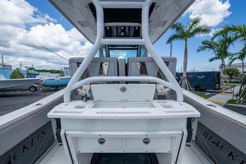 Slide: The Image of 2019 Blackfin 272 CC boat interior with fishing station, palm trees, and blue sky background. - 15