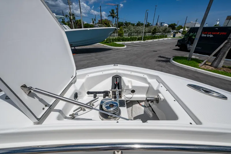 Slide: The Image of 2019 Blackfin 272 CC boat anchor compartment open, showcasing storage and mechanism. - 27