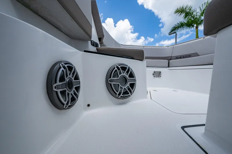 Slide: The Image of 2019 Blackfin 272 CC boat interior with speakers and seating, under a blue sky. - 34