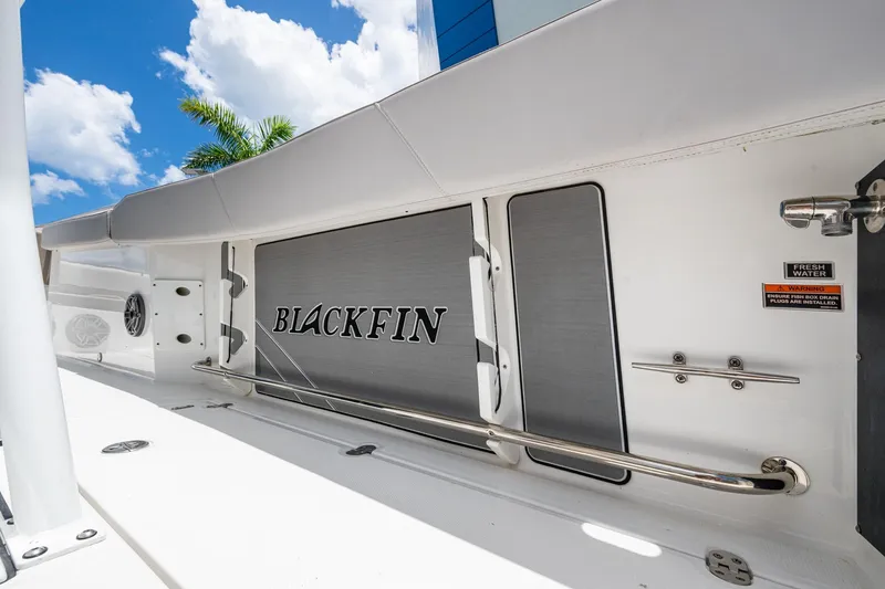 Slide: The Image of 2019 Blackfin 272 CC boat interior with logo, stainless steel rail, and clear sky background. - 40