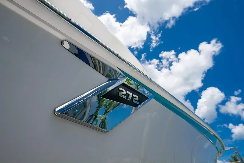 Slide: The Image of 2019 Blackfin 272 CC boat emblem against a bright blue sky with clouds. - 41