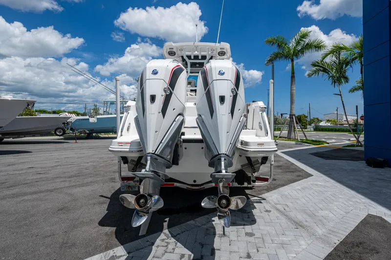 Slide: The Image of 2019 Blackfin 272 CC boat with dual outboard engines, parked under a clear blue sky. - 43