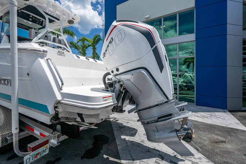 Slide: The Image of 2019 Blackfin 272 CC boat with powerful outboard engine, parked near modern building. - 45
