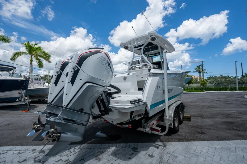 Slide: The Image of 2019 Blackfin 272 CC boat with dual engines on a trailer, under a clear blue sky. - 50