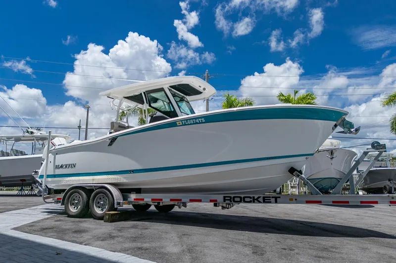 Slide: The Image of 2019 Blackfin 272 CC boat on trailer under blue sky with clouds. - 8