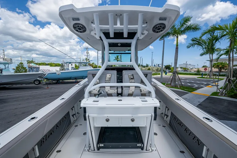 Slide: The Image of 2019 Blackfin 272 CC boat interior with modern console and seating, parked outdoors. - 9