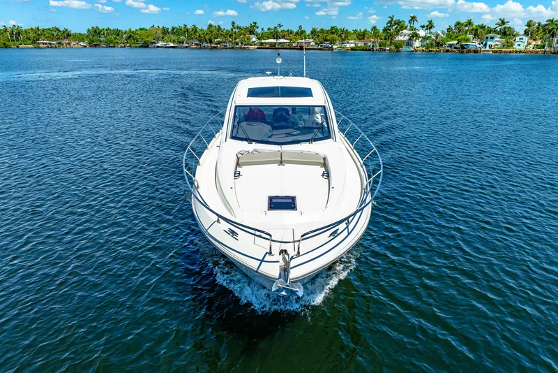 Slide: The Image of 2024 Beneteau Gran Turismo 45 yacht cruising on a serene lake with lush shoreline. - 14