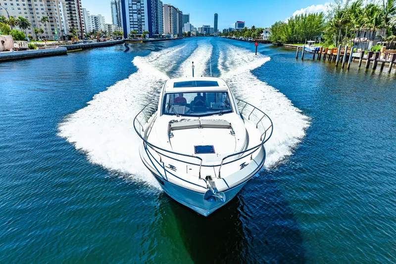 Slide: The Image of 2024 Beneteau Gran Turismo 45 cruising on a scenic waterway with city skyline. - 24