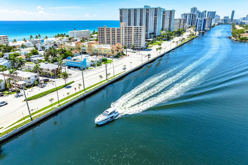 Slide: The Image of 2024 Beneteau Gran Turismo 45 cruising along a scenic coastal waterway. - 29