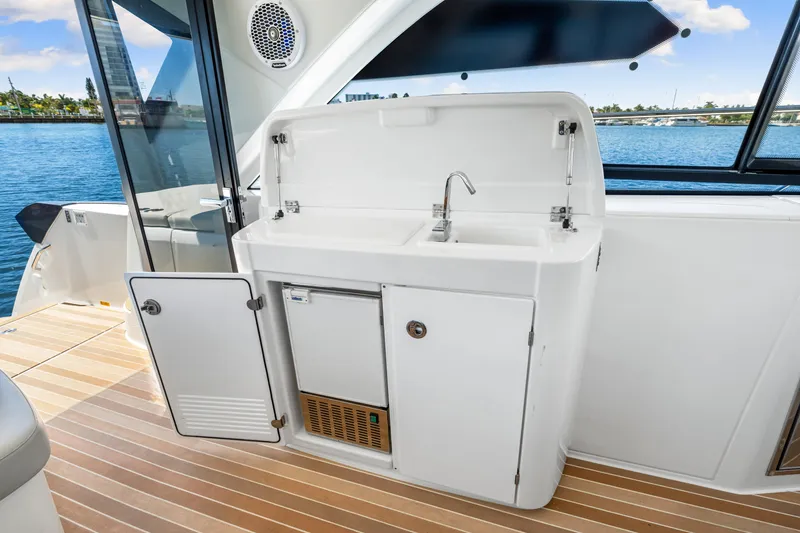 Slide: The Image of 2024 Beneteau Gran Turismo 45 yacht kitchenette with sink and storage, overlooking water. - 48