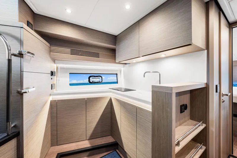 Slide: The Image of Modern kitchen interior of 2024 Beneteau Gran Turismo 45 yacht, featuring sleek cabinetry and ocean view. - 59