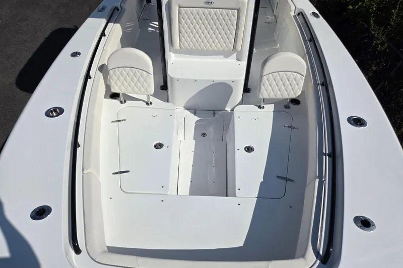 Slide: The Image of 2026 Sea Hunt Gamefish 27 Forward Seating boat interior with white cushioned seats. - 15