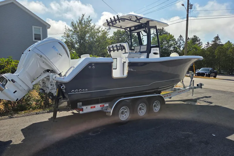 Slide: The Image of 2026 Sea Hunt Gamefish 27 Forward Seating boat on trailer, parked outdoors. - 3