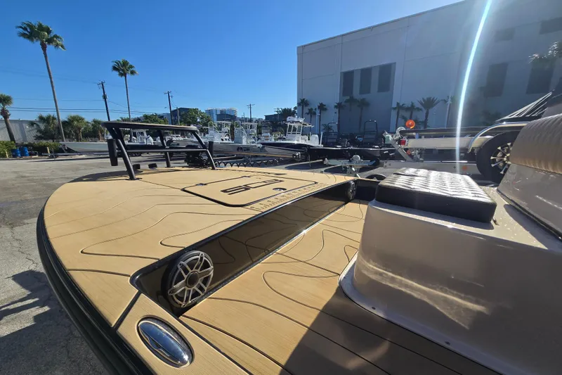 Slide: The Image of 2025 SCB R24 boat with sleek deck design, parked outdoors under clear blue sky. - 5