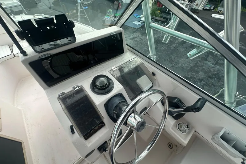 Slide: The Image of 1998 Grady-White Tournament 223 boat dashboard with steering wheel and navigation instruments. - 14