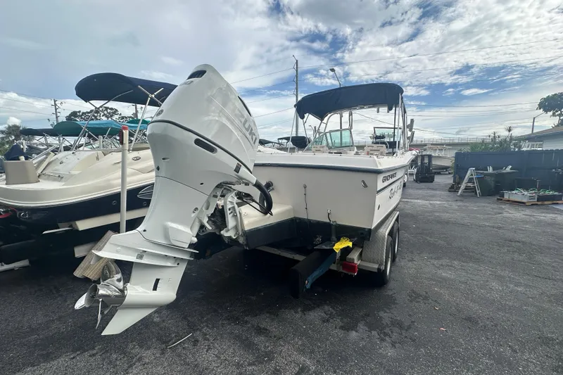 Slide: The Image of 1998 Grady-White Tournament 223 boat with outboard motor on trailer, parked outdoors. - 3