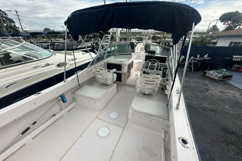 Slide: The Image of 1998 Grady-White Tournament 223 boat with seating and canopy, docked outdoors. - 8