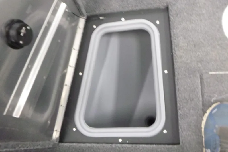 Slide: The Image of 2026 Tracker Pro Guide V-175 WT boat storage compartment with gray trim and carpeted interior. - 11