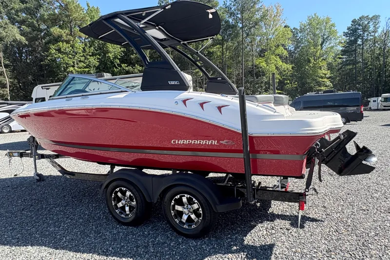Slide: The Image of 2020 Chaparral 21 SSi boat in red, parked on a trailer in a sunny outdoor setting. - 1