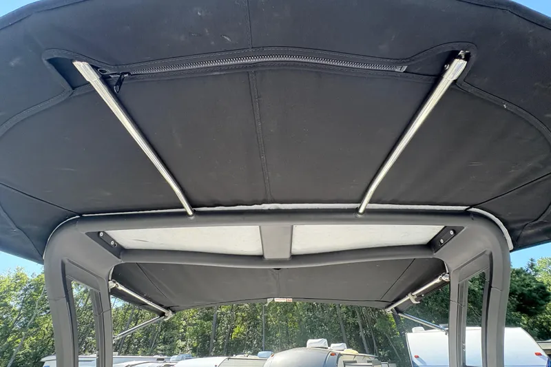 Slide: The Image of 2020 Chaparral 21 SSi boat canopy with metal support rods, outdoor setting. - 16