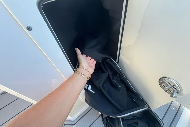 Slide: The Image of Hand accessing storage compartment on 2020 Chaparral 21 SSi boat. - 9