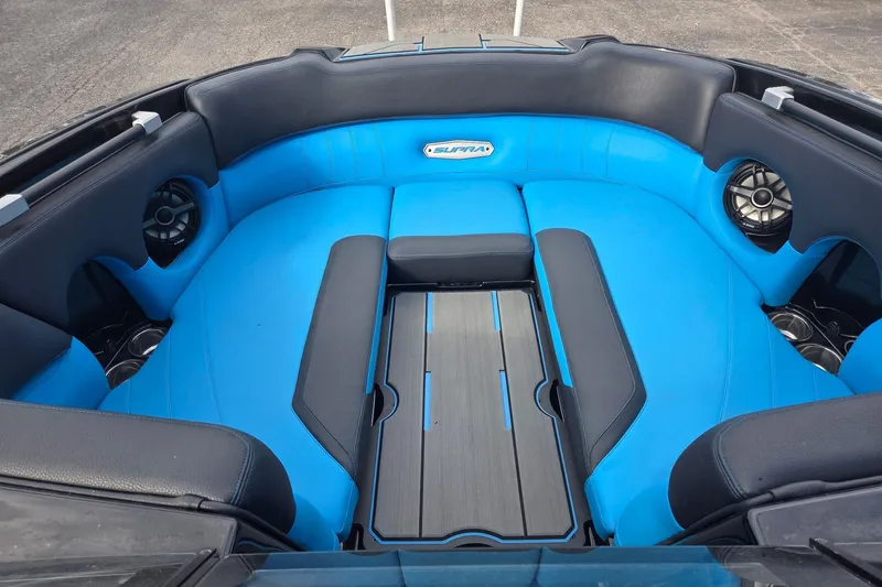 Slide: The Image of 2021 Supra SE 450 boat interior with blue and black seating, featuring built-in speakers. - 8