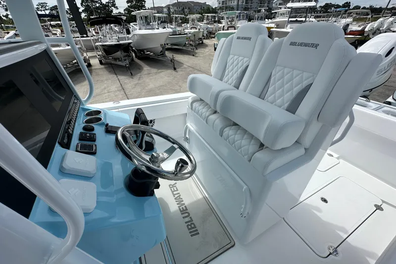Slide: The Image of 2026 Bluewater 25t boat interior with steering wheel and cushioned seating. - 15