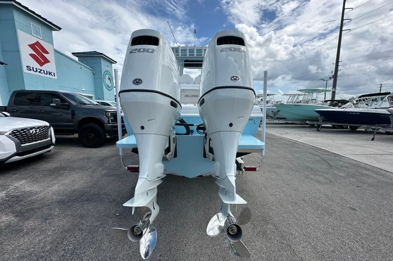 Slide: The Image of 2026 Bluewater 25t boat with dual 200 horsepower engines at a dealership. - 4