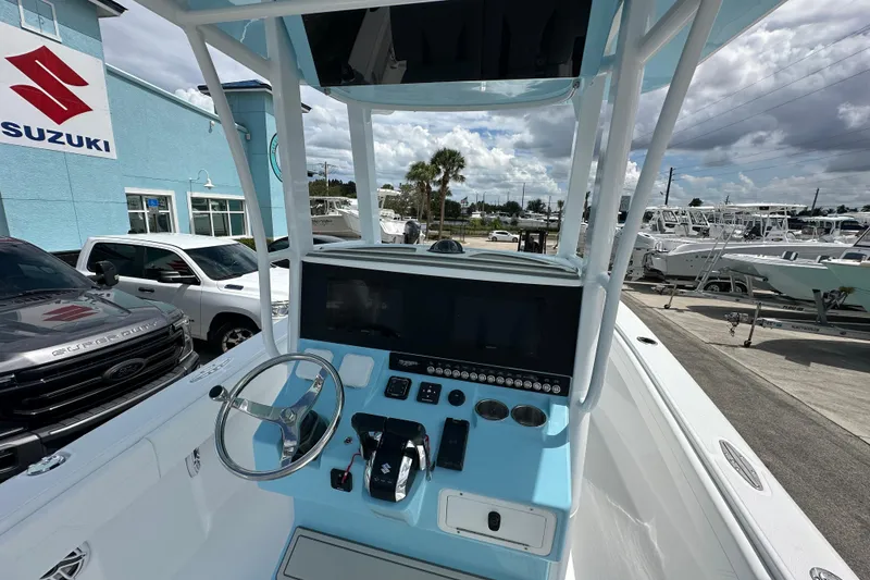 Slide: The Image of 2026 Bluewater 25t boat dashboard with steering wheel, controls, and display at a Suzuki dealership. - 6