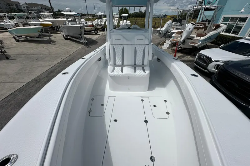 Slide: The Image of 2026 Bluewater 25t boat with spacious deck and seating, displayed at a marina. - 9